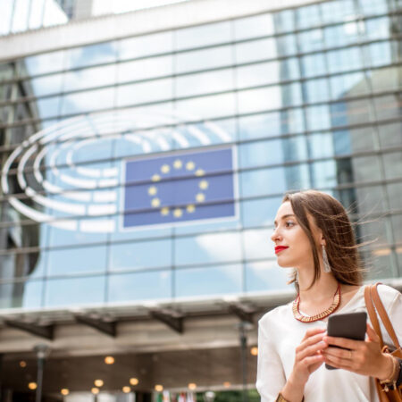 joven empresaria pie telefono cerca edificio parlamento union europea ciudad bruselas